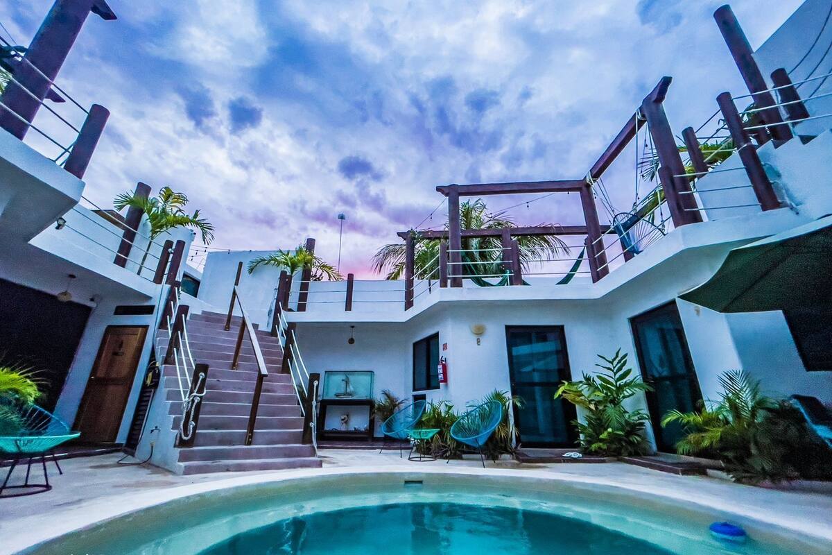 A modern building with a pool, stairs, and outdoor seating.