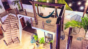 A multi-level outdoor area with a hammock, seating, and potted plants. - Hotel Ade (Bacalar)