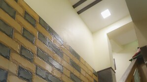 A staircase with a wooden handrail and a patterned wall. - Hotel Plaza Executive Kurla (Mumbai)