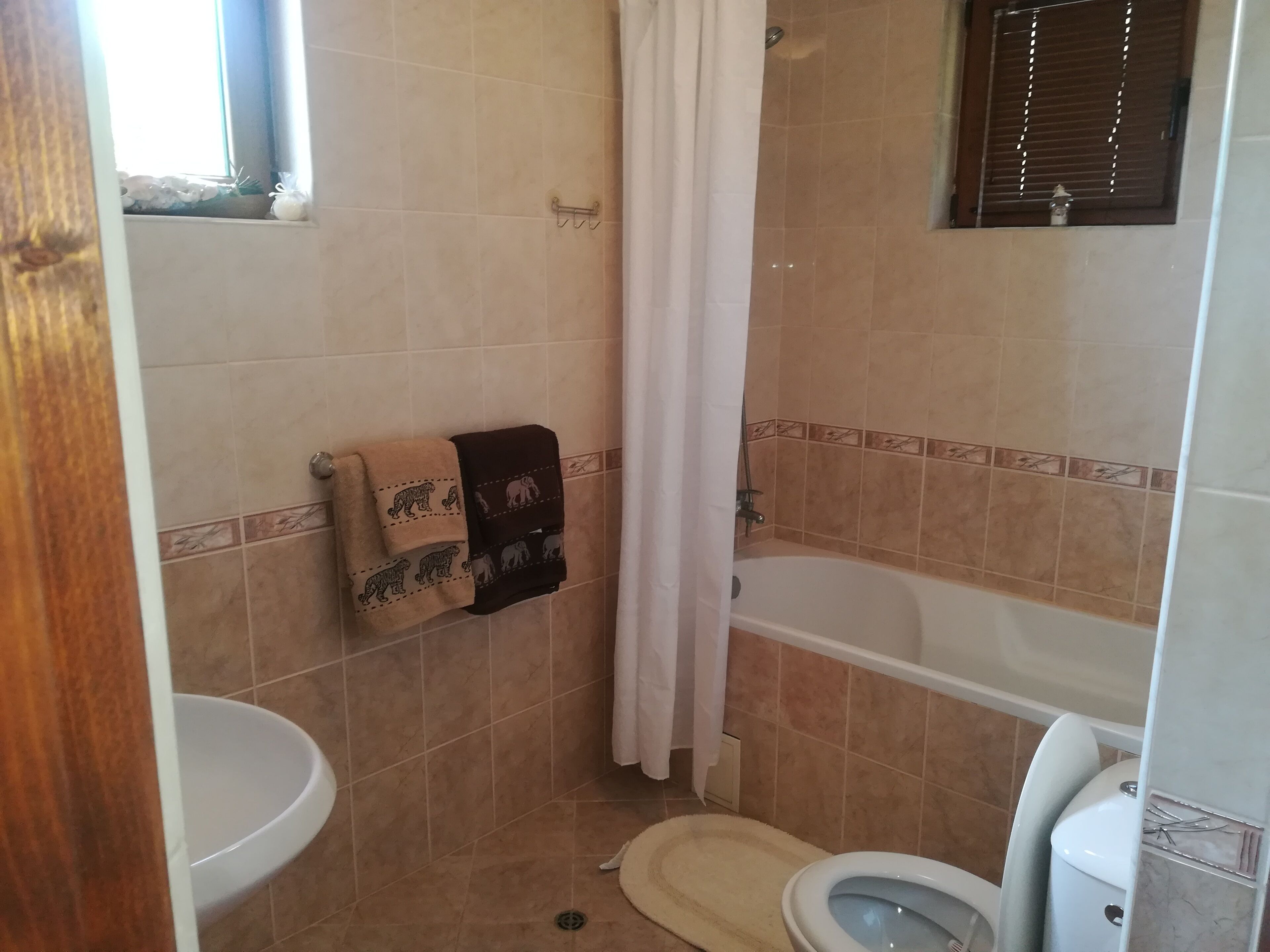 Un baño con inodoro, bañera y cortina de ducha.