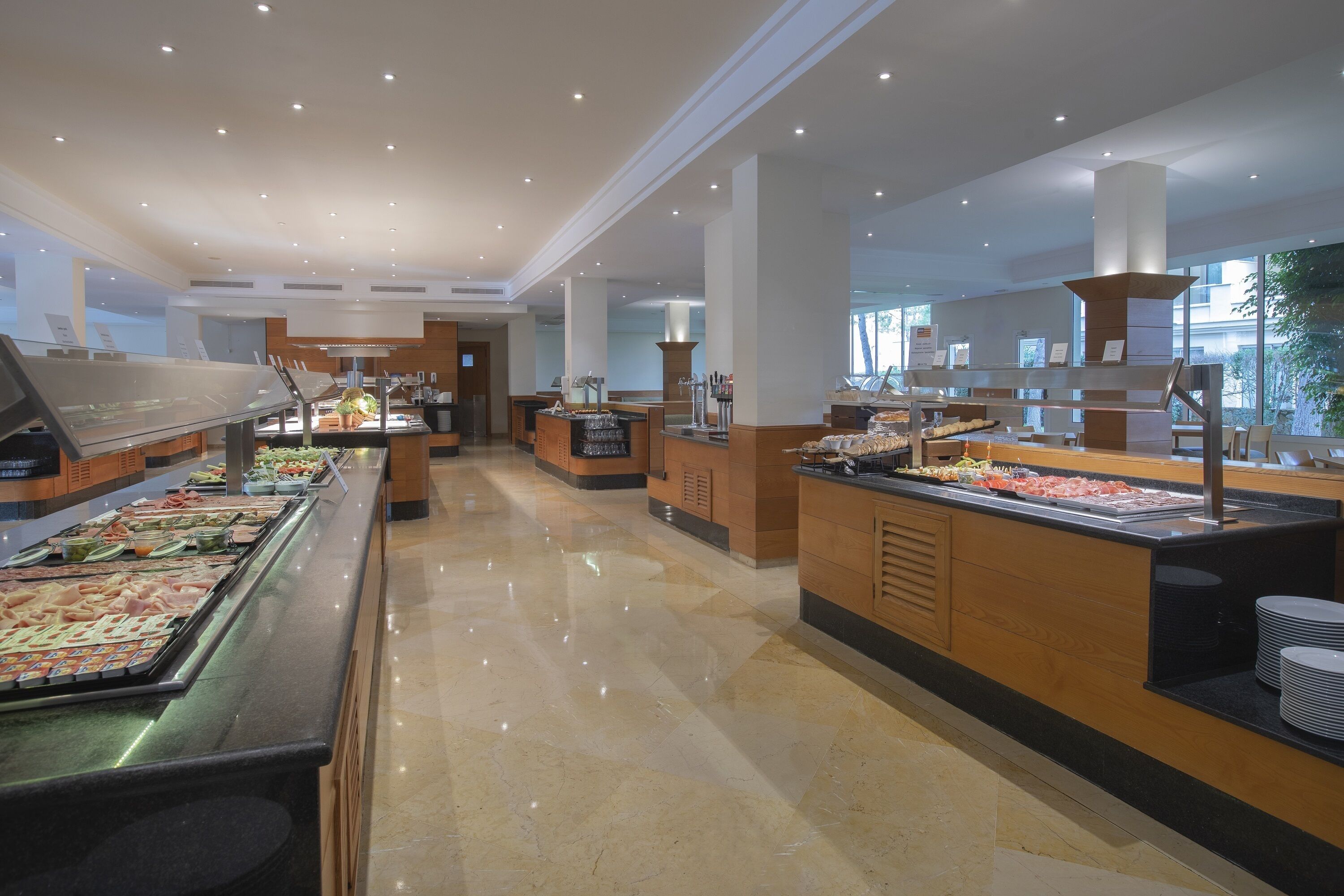 A buffet area with various food stations, a clean floor, and a modern interior design.