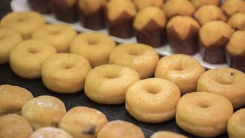 A display of various donuts, including glazed and chocolate varieties, arranged on a tray.