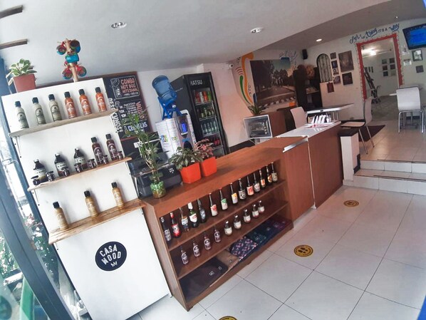 A bar area with shelves of bottles, a counter, and a sign that reads "CASAWOOD." - Casa Mood Usaquen - Hostel (Bogotá)