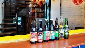 Un espace bar avec différentes sortes de bières en bouteille et un panneau indiquant « Bar à bières ».