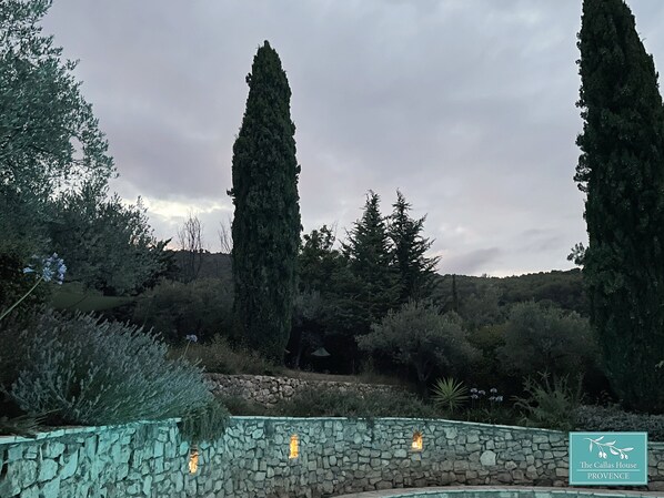 A stone wall with a stone pool, surrounded by cypress trees and a stone wall with a lantern. - Beautiful stone house in olive grove, great pool area and garden, panoramic view (Callas)