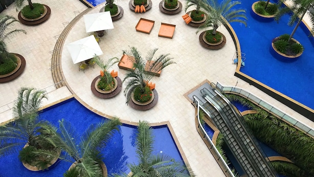 A pool area with multiple seating arrangements, palm trees, and a water slide. - Landscape Beira Mar, Lindo, Luxo, Vista mar (Fortaleza)