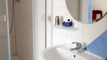 Standaard tweepersoonskamer | Badkamer | Een douche, gratis toiletartikelen, een haardroger, handdoeken