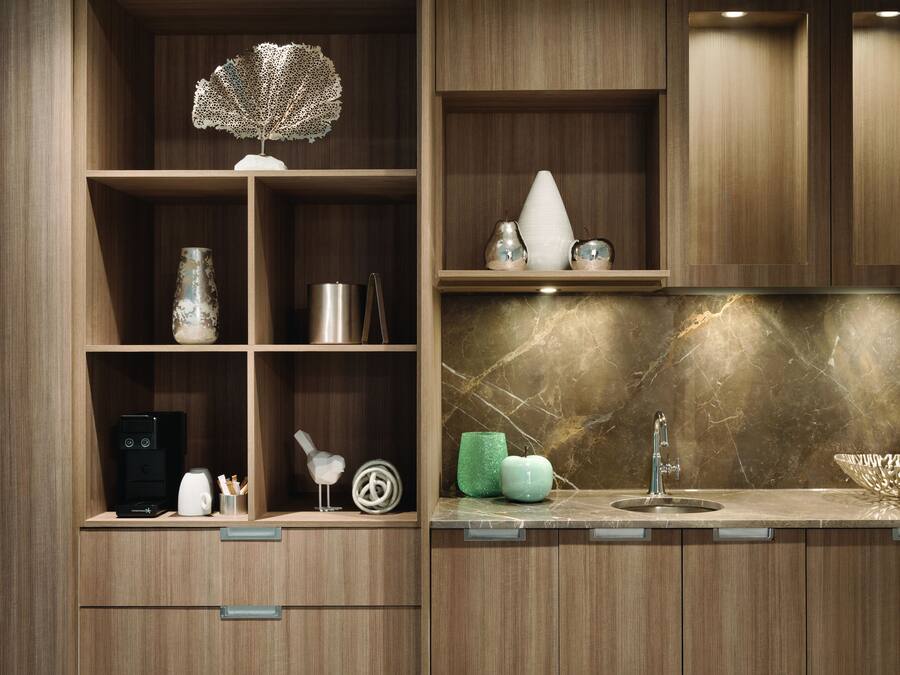 Een moderne keuken met houten kastjes, een marmeren spatwand en een spoelbak.