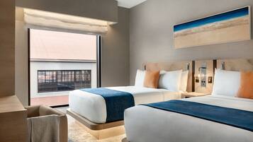 Habitación de hotel moderna con dos camas, un ventanal con vistas a un edificio y un cuadro en la pared.