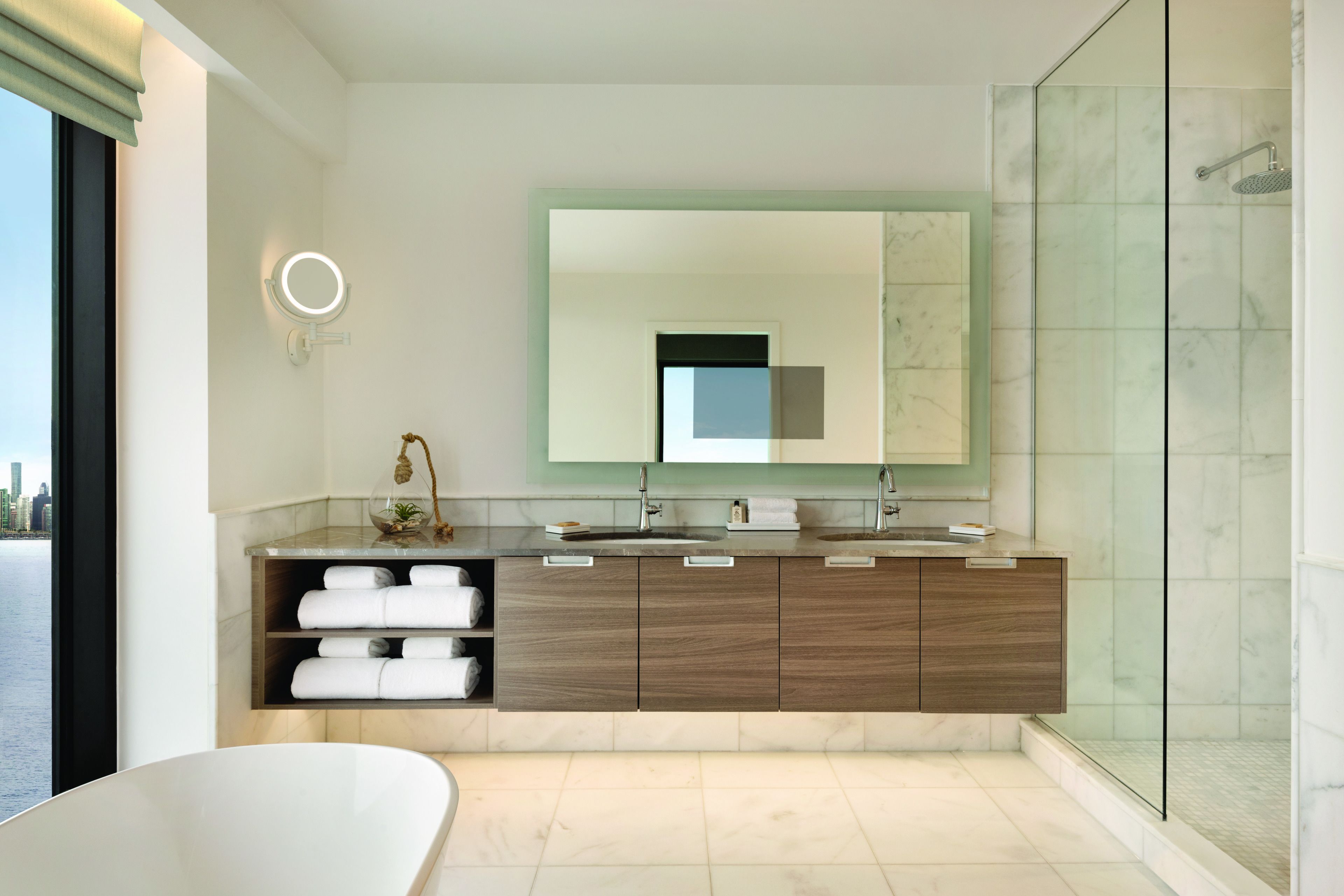 Une salle de bain moderne avec un grand miroir, une baignoire et un espace douche.
