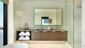 Une salle de bain moderne avec un grand miroir, une baignoire et un espace douche.