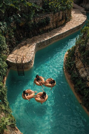 A pool with clear water, surrounded by stone walls and greenery. - Hacienda Cenote San Ignacio (Chocholá)