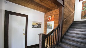 A wooden staircase with a handrail leading to a door with a brass doorknob. - Downtown Historic Neighborhood, great location. (San Antonio)