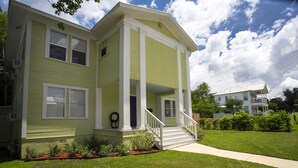 A two-story house with a front porch, a staircase leading to the entrance, and a well-maintained lawn. - Downtown Historic Neighborhood, great location. (San Antonio)