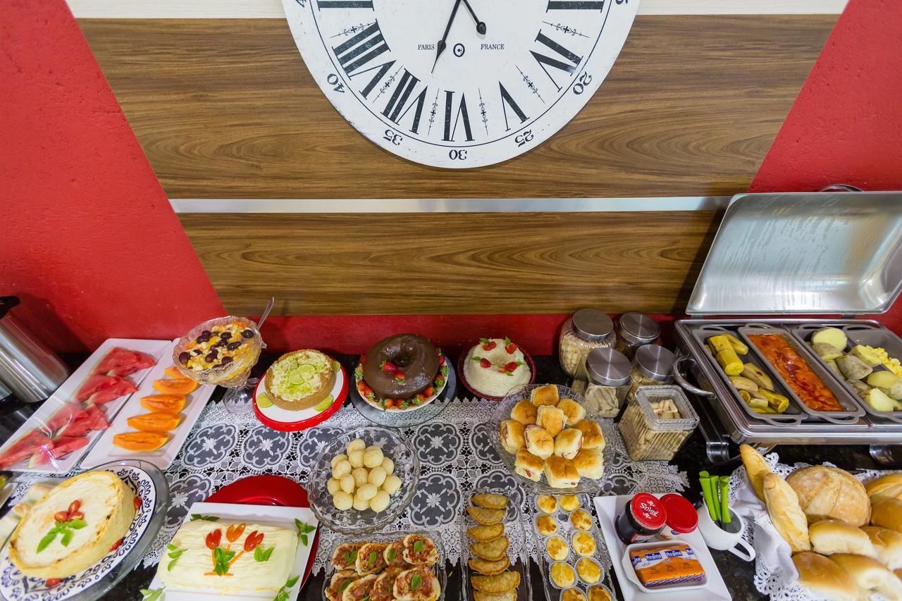 A buffet table with various food items and a clock above it.