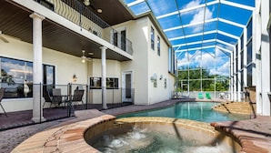 A swimming pool with a hot tub, outdoor seating, and a covered patio area. - Stunning Large 7 bed Home With Private Pool, Spa, Balcony, Cinema Room, Fitness Suite and Able to see the Disney Fireworks - 467 (Kissimmee)