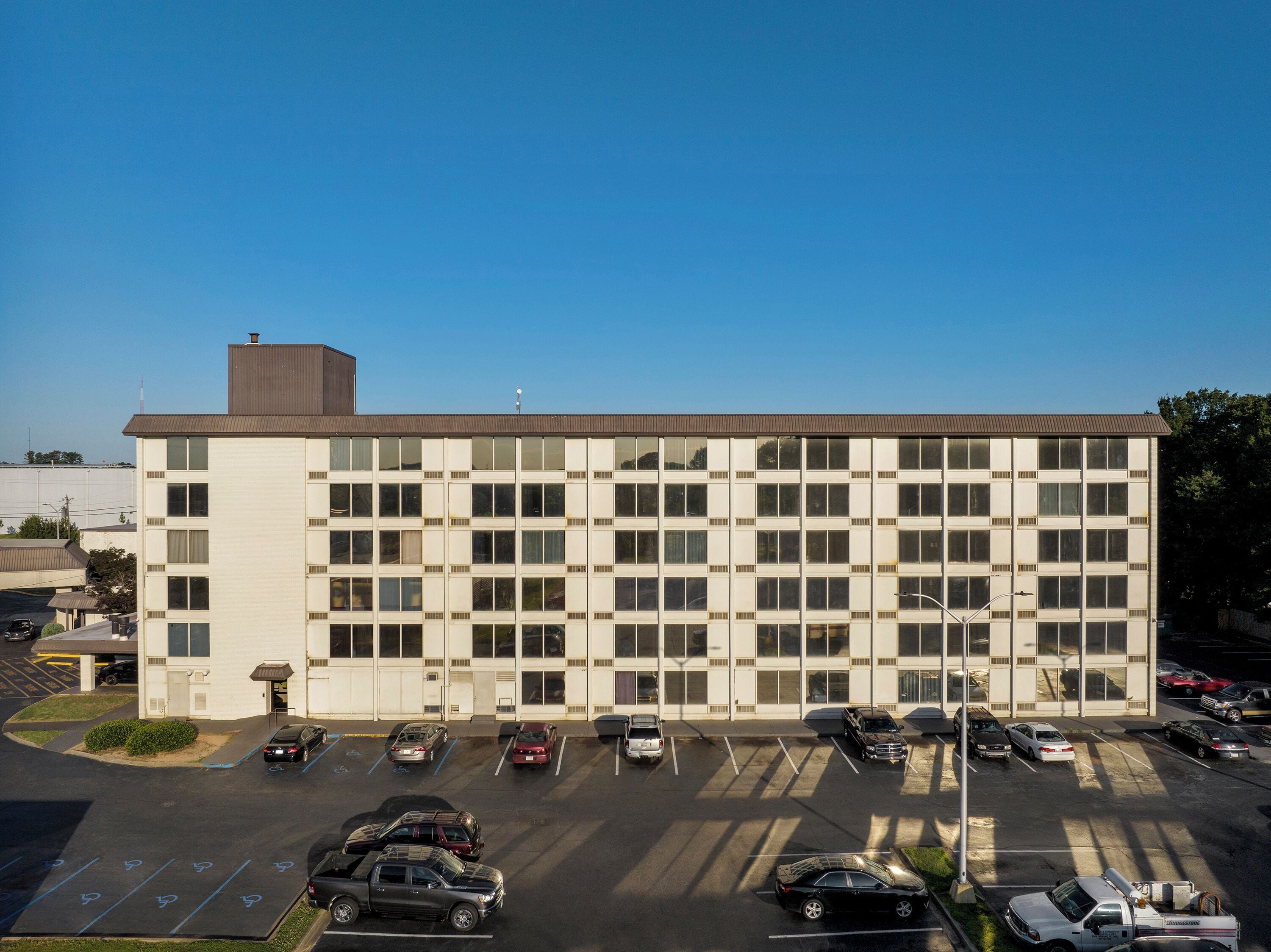 A multi-story building with a parking lot in front.