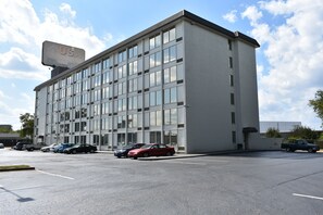 A modern building with a USA sign, parking lot, and several parked cars. - USA Economy Lodge (Spartanburg)