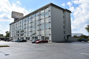 Un edificio moderno con un cartel de USA, estacionamiento y varios coches aparcados.