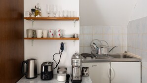 Eine kleine Küche mit Kaffeemaschine, Toaster, Wasserkocher und Spüle.