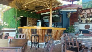 An outdoor bar area with wooden furniture and a rustic design. - Hotel Nature Lodge Finca los Caballos (Cóbano)