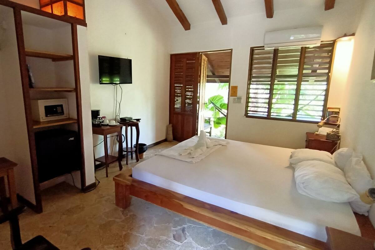 Un dormitorio con cama, escritorio, televisor y armario.
