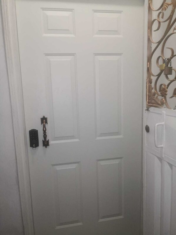 Une porte blanche avec un trou de serrure et un bouton de sonnette.