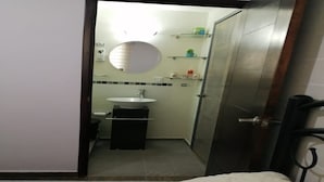 A small, compact bathroom with a round mirror, a sink, and a toilet. There are shelves above the sink and a door leading to another room. - 2 single rooms, and 1 double room with their private bathroom, kitchen.microwave (QUERETARO)