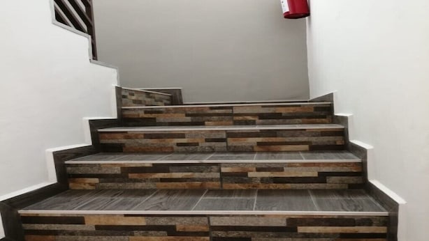 A staircase with a modern design, featuring a combination of dark and light wood-like steps. - 2 single rooms, and 1 double room with their private bathroom, kitchen.microwave (QUERETARO)