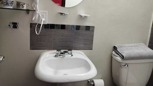 A bathroom with a white sink, a hairdryer, a toilet, and a mirror. - 2 single rooms, and 1 double room with their private bathroom, kitchen.microwave (QUERETARO)