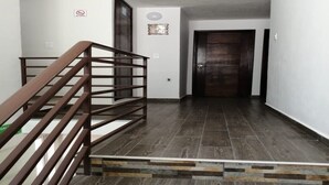 A staircase with a wooden handrail leading to a dark wooden door. - 2 single rooms, and 1 double room with their private bathroom, kitchen.microwave (QUERETARO)