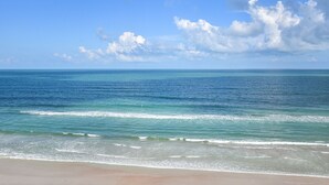 Ein Strand mit klarem, blauem Wasser und sandigem Ufer.