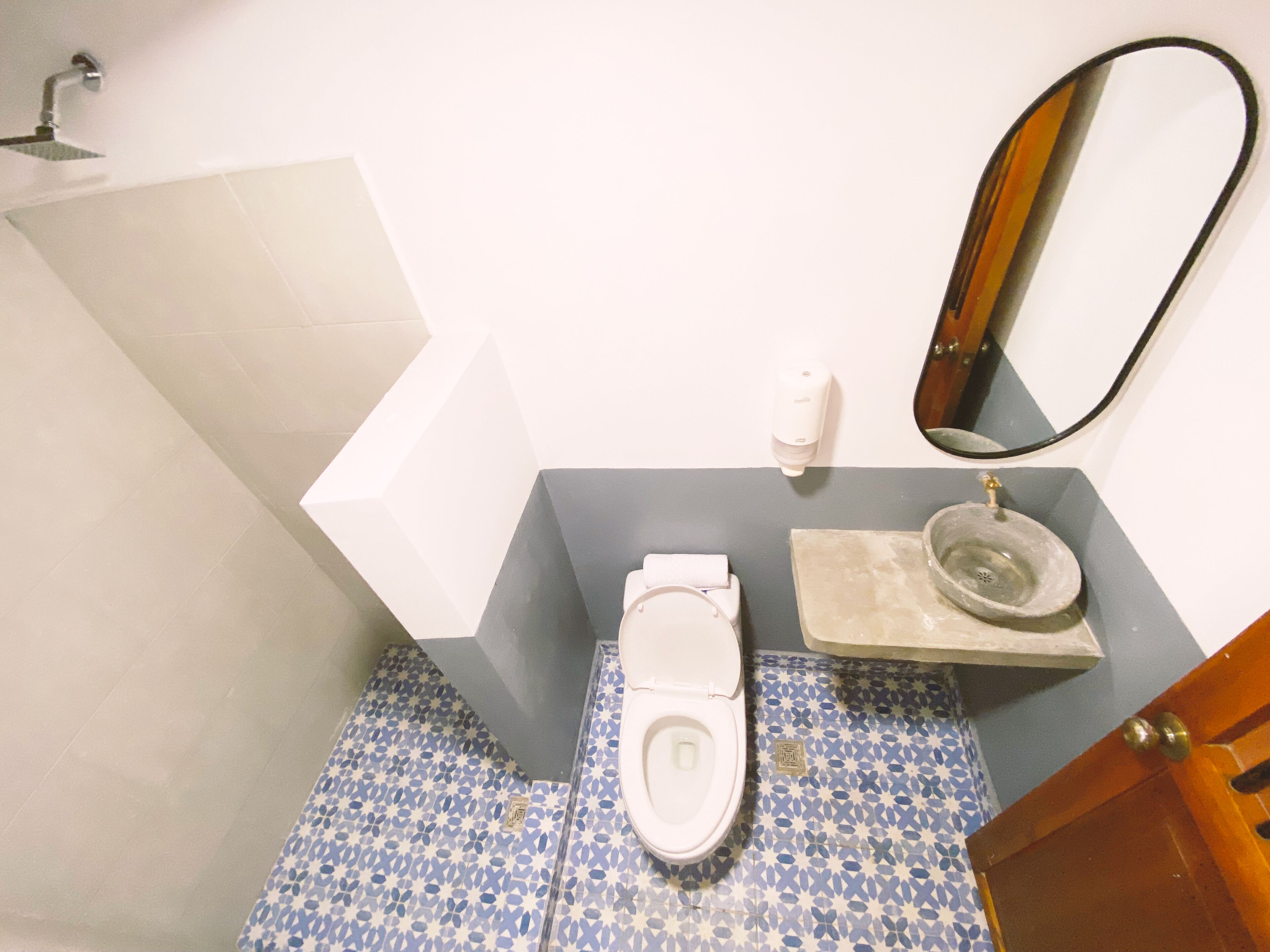 A bathroom with a toilet, sink, and mirror.