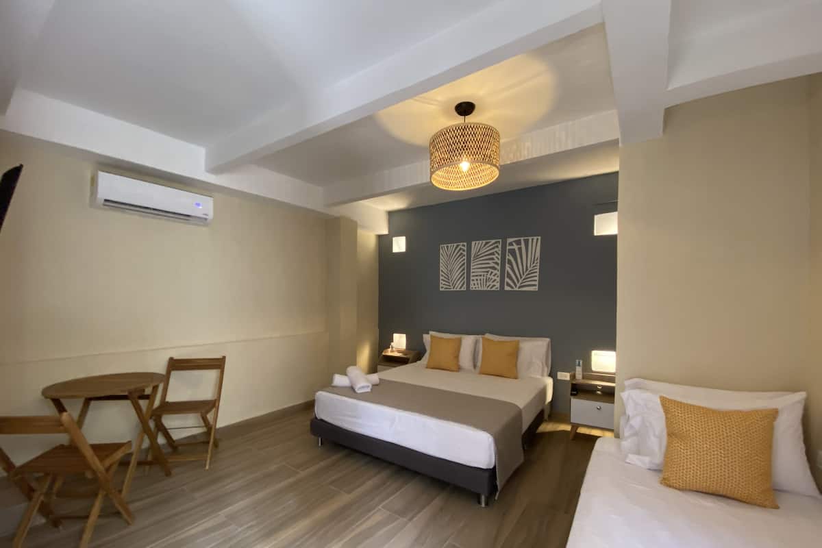 Een hotelkamer met een bed, nachtkastjes, een bureau en stoelen.