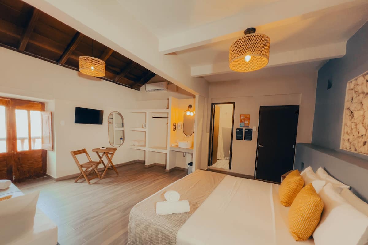 Een hotelkamer met een bed, een bureau, een stoel, een spiegel en een kledingkast.