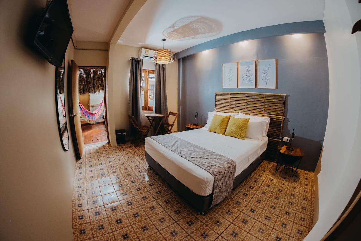 Een hotelkamer met een bed, een televisie, een klein tafeltje en een stoel.
