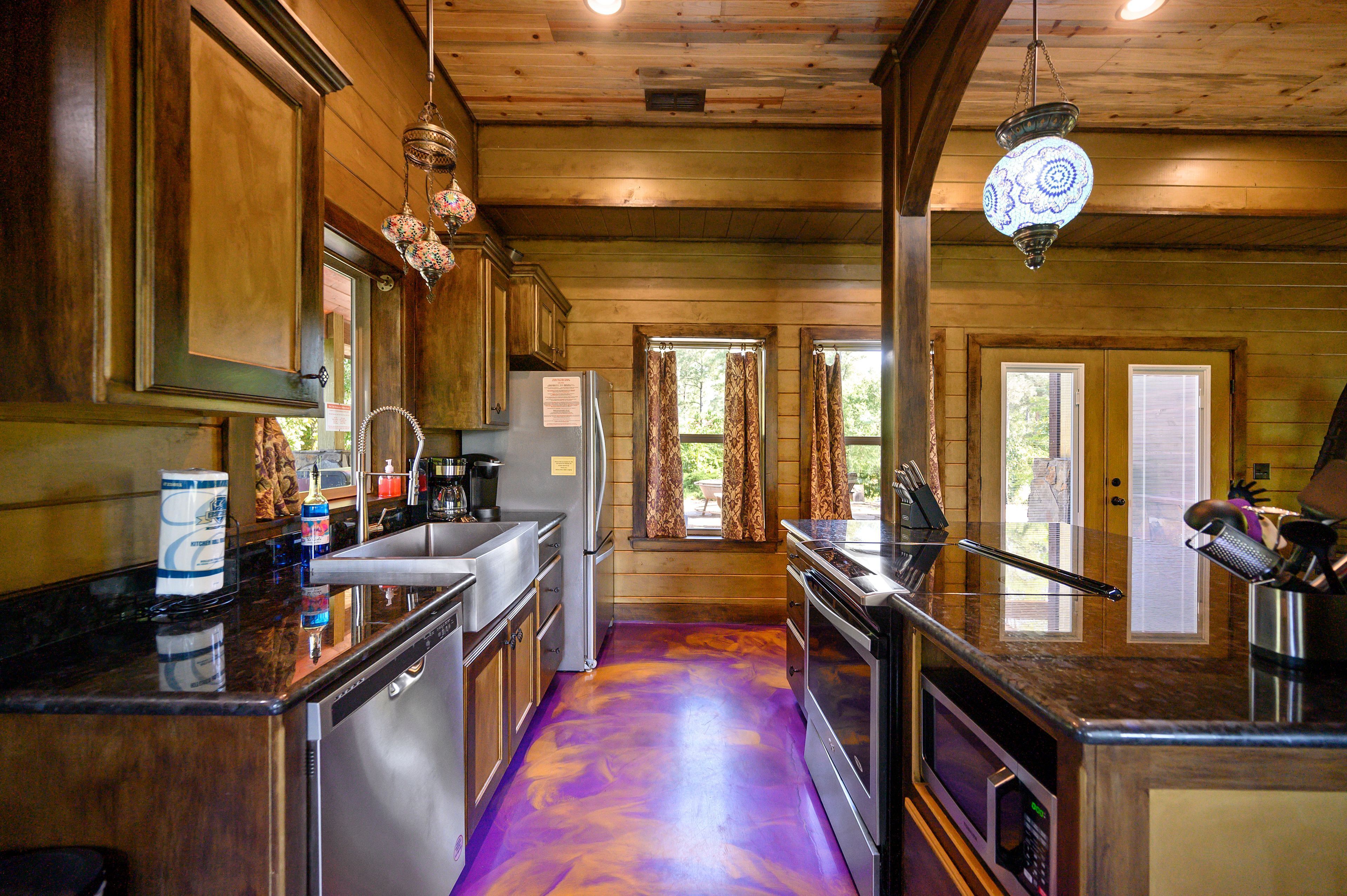 A kitchen with wooden cabinets, a stainless steel refrigerator, and a purple floor.