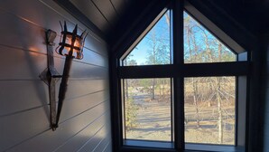 Ein Zimmer mit großem Fenster und einer Wandleuchte.