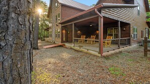 A rustic log cabin with a covered porch and outdoor seating area. - Caddy Shack | Luxury Group Lodge Near Broken Bow Lake with Game Room and Expansi (Broken Bow)