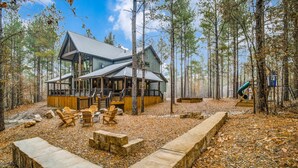Une cabane dotée d’une terrasse, d’un coin salon et d’un foyer.