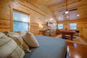 Ein gemütliches Blockhaus-Zimmer mit Bett, Billardtisch und Essbereich.
