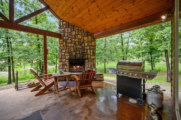 Enjoy al fresco dining and relaxation in this serene outdoor space with a fireplace and grill.
