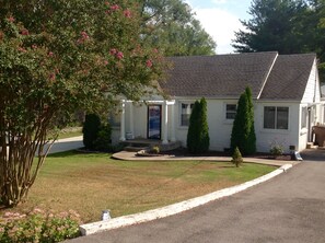 A single-story house with a front porch, a small front yard, and a driveway.