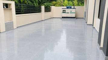 A spacious, modern outdoor area with a flat, tiled floor and a water dispenser.