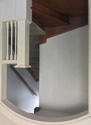 Staircase leads to an upper floor with a handrail for support.