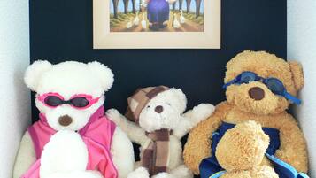 Three teddy bears sitting on a shelf.