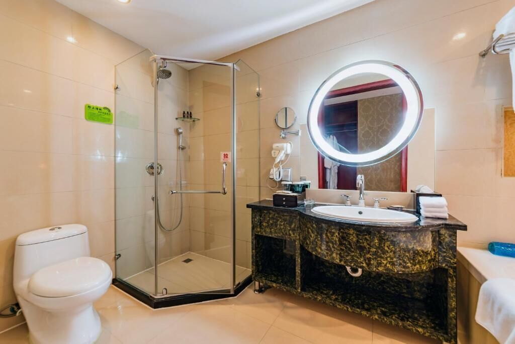 A modern bathroom with a glass-enclosed shower, a sink with a vanity, and a large mirror.