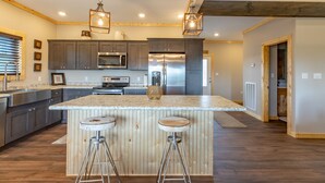 Una cocina moderna con una isla central, electrodomésticos de acero inoxidable y detalles de madera.