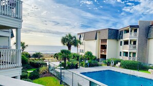 A residential building with a swimming pool, a view of the ocean, and a well-maintained garden. - Beautiful beach Condo with ocean and pool view, very family oriented.  (Myrtle Beach)