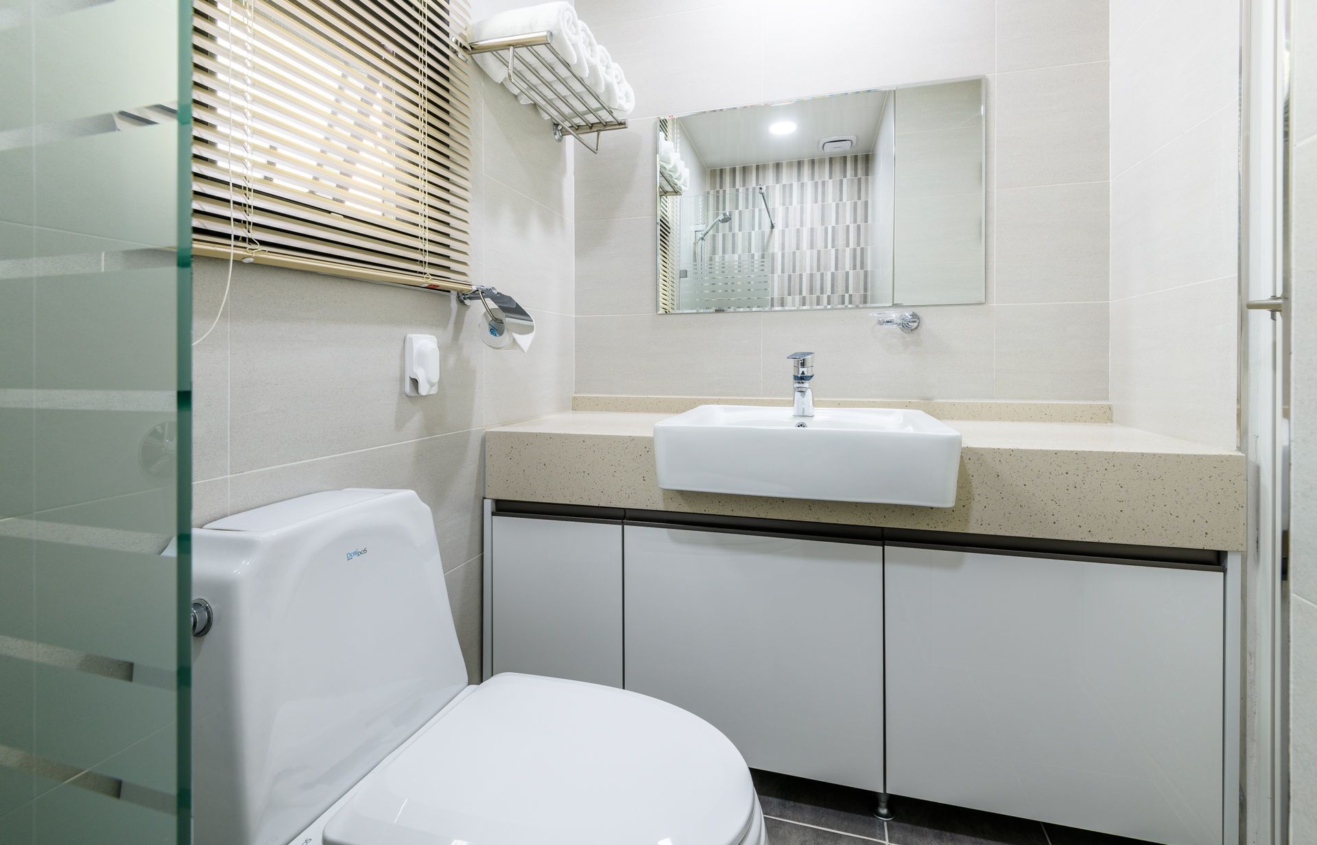 A modern bathroom with a toilet, sink, and shower.